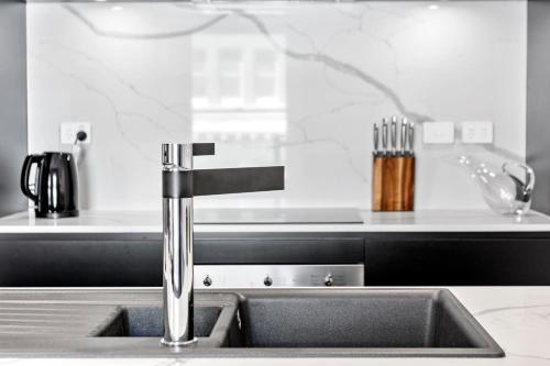 eine Küchenspüle mit einem Wasserhahn in der Küche in der Unterkunft Saddlers House - City View - Cafe Lifestyle in Hobart