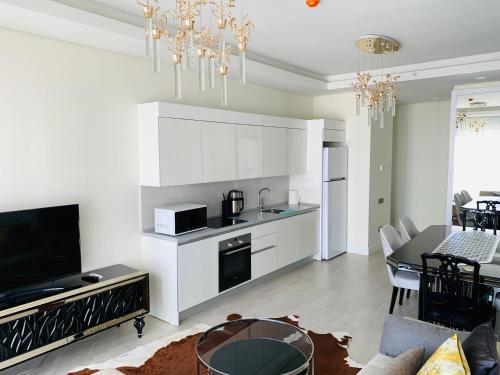 a kitchen and living room with white cabinets and a table at Luxury House Ankara in Ankara