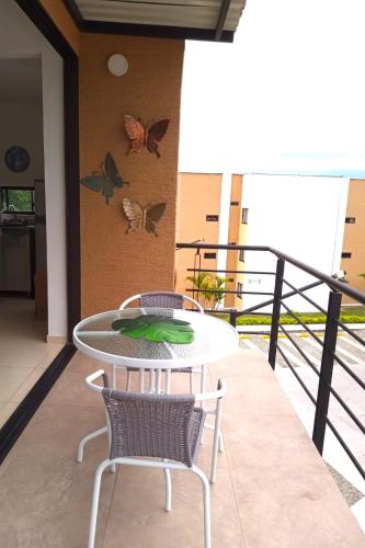 a table and chairs on a balcony with butterflies on the wall at Apartasol Amor y Café, Reserva de la Colina in La Tebaida