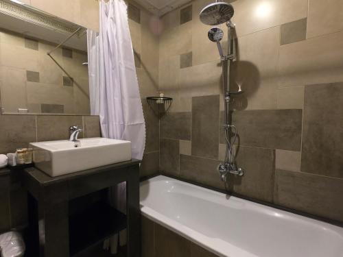 a bathroom with a sink and a bath tub with a shower at Borg El Thaghr Hotel in Alexandria