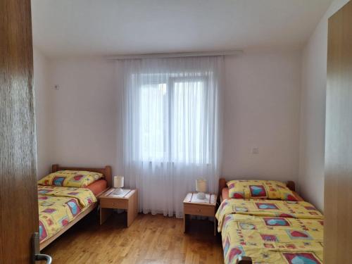 two beds in a small room with a window at Apartments with a parking space Vantacici, Krk - 5425 in Vantačići