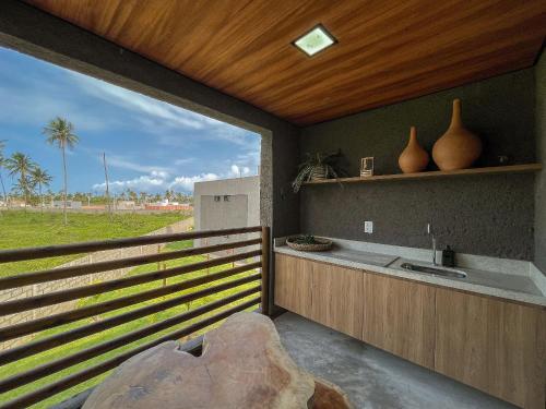 eine Küche mit einer Spüle und Blick auf ein Feld in der Unterkunft Villas Manatee Apartamento G103 Nobile Stays in Tatuamunha