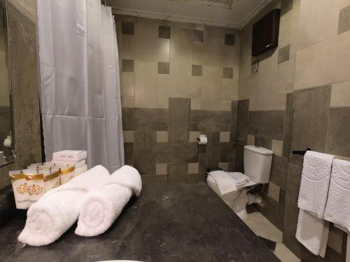 a bathroom with a toilet and towels in it at Borg El Thaghr Hotel in Alexandria