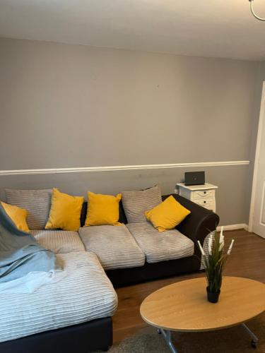 a living room with a couch with yellow pillows at Southend Lane Suites in Forest Hill