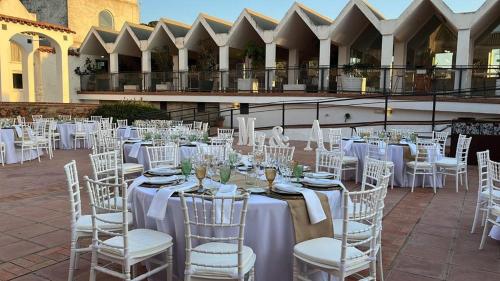 a group of tables and chairs with white tables and chairsearcher at Hotel La Alcoholera in Villaviciosa de Córdoba