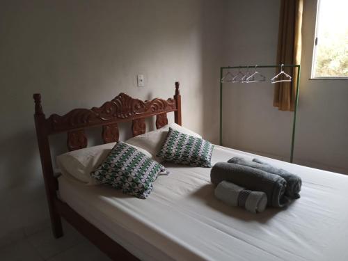 Una cama con dos almohadas encima. en CASA TEMPORADA DONA CECÍLIA, en Cavalcante