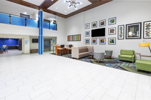 a lobby with a waiting area with chairs and a table at Holiday Inn Express & Suites Sulphur - Lake Charles, an IHG Hotel in Sulphur