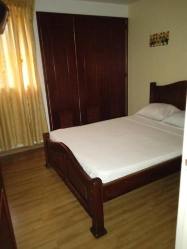 a bedroom with a bed with a wooden headboard at Apartamentos en Mérida Mejor precio garantizado in Mérida