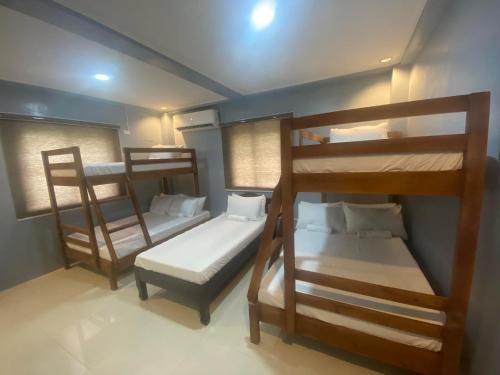 a room with three bunk beds and a bed at Lakayo Hillside Apartelle in san juan la union