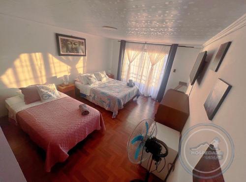 Habitación pequeña con 2 camas y ventilador. en Habitaciones en casa de alojamiento sector sur de Iquique, Chile, en Iquique