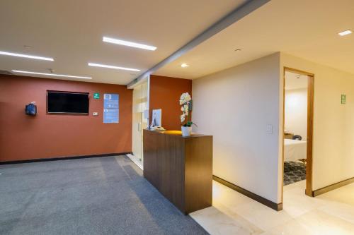 an office with a hallway with a tv on a wall at Camino Real Pedregal Mexico in Mexico City