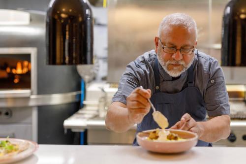 a man in a kitchen eating a bowl of food at Holiday Inn Dandenong by IHG in Dandenong