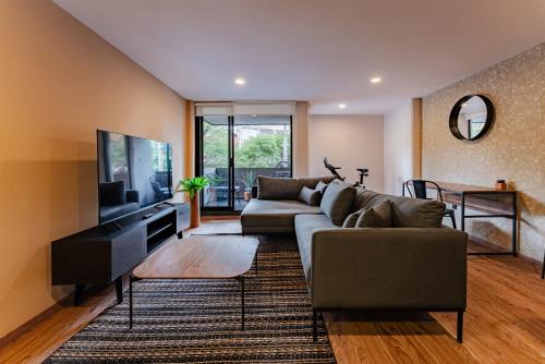 a living room with a couch and a tv at Sonora 11 Apartments by VH in Mexico City