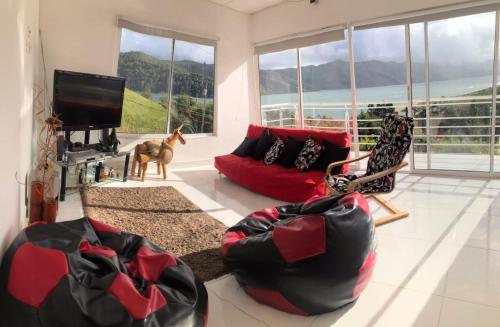 a living room with a red couch and a dog in it at Lago calima home in Darién