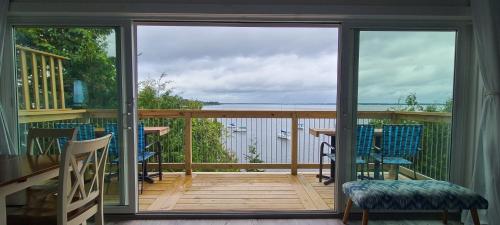 a screened in porch with a view of the water at Loza house coastal design unit with lake & mountain views in Plattsburgh