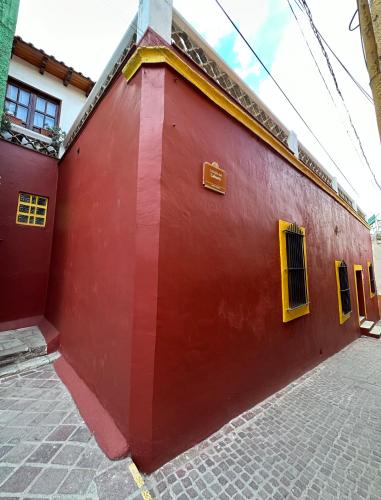 a red building with yellow shutters on it at Antigua Casa del Limon in Guanajuato