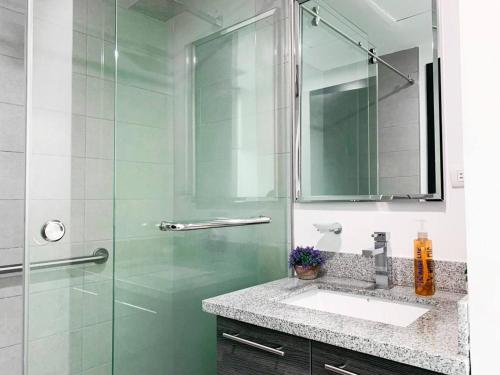 a bathroom with a glass shower and a sink at Lujoso depa con vista a todo Guayaquil! in Guayaquil