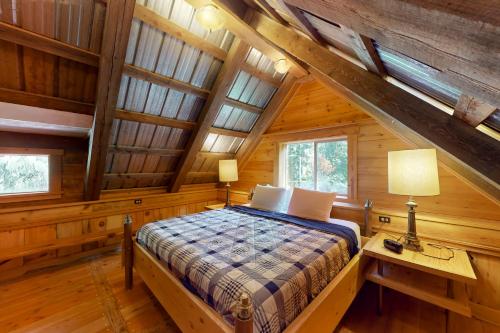 a bedroom in a log cabin with a bed and a desk at The Canopy House in Clinton