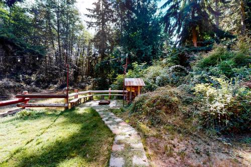 a wooden fence next to a path in a forest at The Canopy House in Clinton