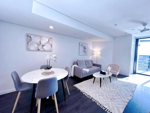 a living room with a table and a couch at Brisbane Riverfront Oasis 2Bed Panoramic RiverView in Brisbane