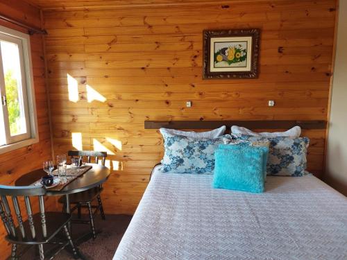 a bedroom with a bed and a table in a room at Sítio Rancho crioulo in Urubici