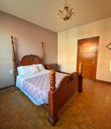 a bedroom with a bed and a chandelier at Alma mía - Hospedaje Cholula in Cholula