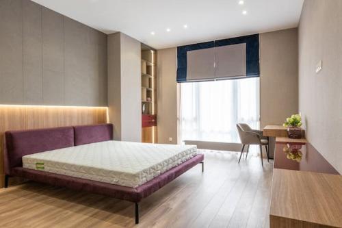 普里什蒂納的住宿－Residence Prishtina，一间卧室配有一张床、一张桌子和一个窗户。