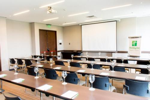 a classroom with tables and chairs and a whiteboard at Holiday Inn Bogota Airport by IHG in Bogotá