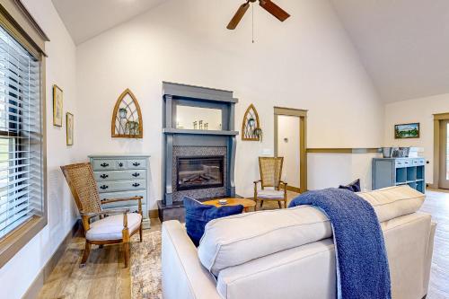 a living room with a white couch and a fireplace at Firefly Meadows in Ellijay