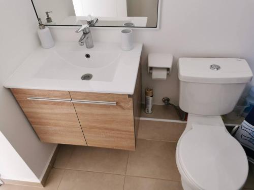 La salle de bains est pourvue de toilettes blanches et d'un lavabo. dans l'établissement Lomas 5, à Papudo