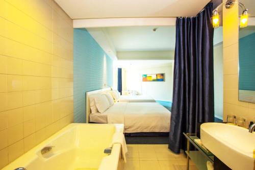 a bathroom with a bed and a bath tub and a bedroom at Weihai Haiyue Jianguo Hotel in Weihai