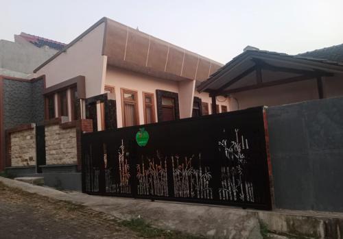 ein Haus mit einem Zaun mit Graffiti drauf in der Unterkunft Samawa Homestay syariah Batu in Tlekung