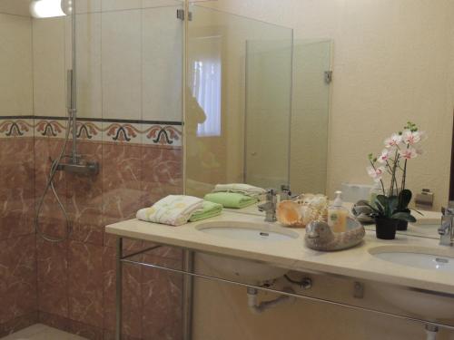 baño con 2 lavabos y espejo grande en Studio Flat with Pool, en Funchal