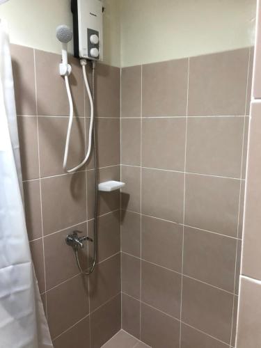 a shower with a shower head in a bathroom at Brenthill Premium Condo Baguio City with Generator in Baguio