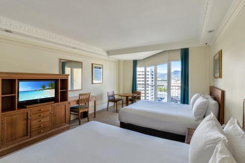 a hotel room with two beds and a flat screen tv at Pullman Cairns International in Cairns