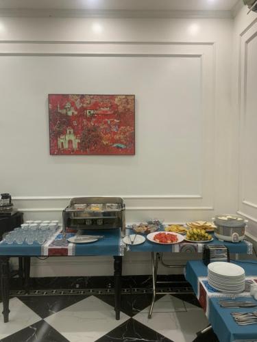 a table with plates of food and a painting on the wall at Đại Thủy Hotel CatBa in Cat Ba