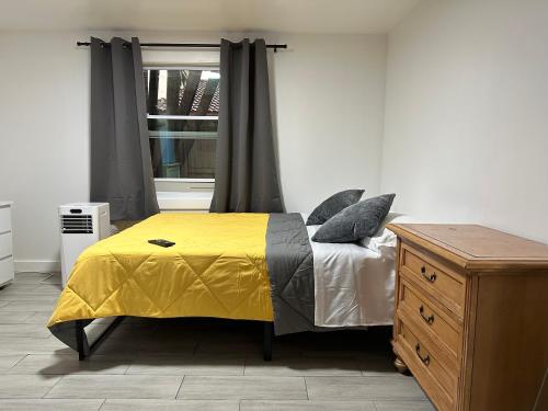 a bedroom with a yellow bed and a window at SERENE FULL BED NEAR DOLPHIN MALL/FIU in Miami