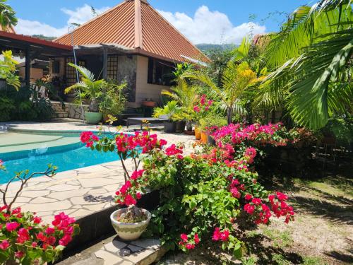una casa con flores rosas y una piscina en Fare Cocoon, en Punaauia