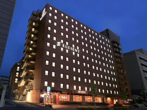 a tall building with lights on in a city at Hotel Elcient Kyoto Hachijoguchi in Kyoto