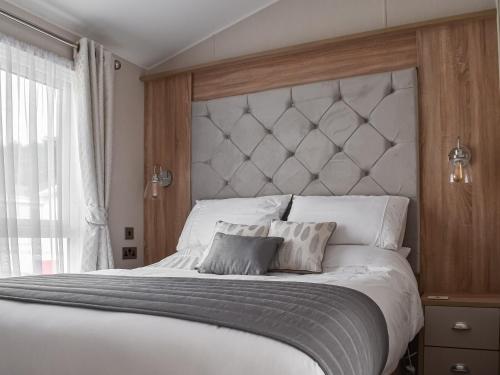 a bedroom with a large white bed with two pillows at Copse View in Kelsale