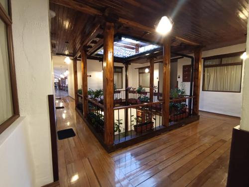 een kamer met houten vloeren en een balkon met planten bij Casona Tobar Hotel in Rocafuerte