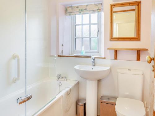 a bathroom with a sink and a toilet and a bath tub at Old Orchard Cottage in Dilton