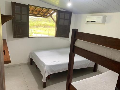 a bedroom with two bunk beds and a window at Chácara Maluco Beleza 4 in Gravatá