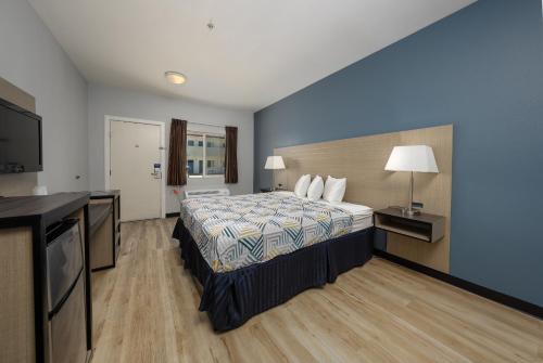 a hotel room with a bed and a flat screen tv at Baymont by Wyndham Ridgecrest in Ridgecrest