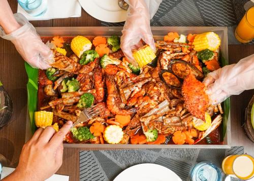 a tray of food with shrimp and vegetables on a table at Courtyard by Marriott Setia Alam in Setia Alam