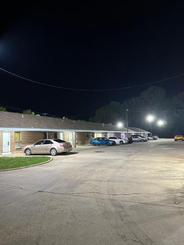 un parking avec des voitures garées devant un bâtiment dans l'établissement Travel Inn Montgomery AL, à Montgomery