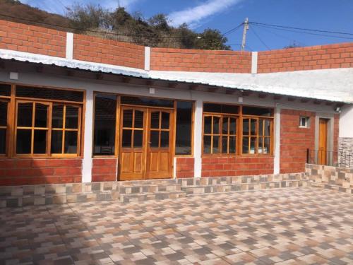 un edificio de ladrillo con puertas y ventanas de madera en La escondida en Salta