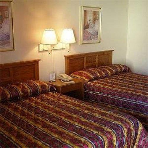 a hotel room with two beds and a telephone at Red Carpet Inn Starke in Starke