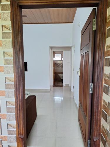a hallway with a door leading into a room at Suvarna Grande Homes in Mangalore