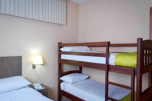 a room with two bunk beds and a lamp at HOTEL MANTA BEACH MADRIGAL in Manta
